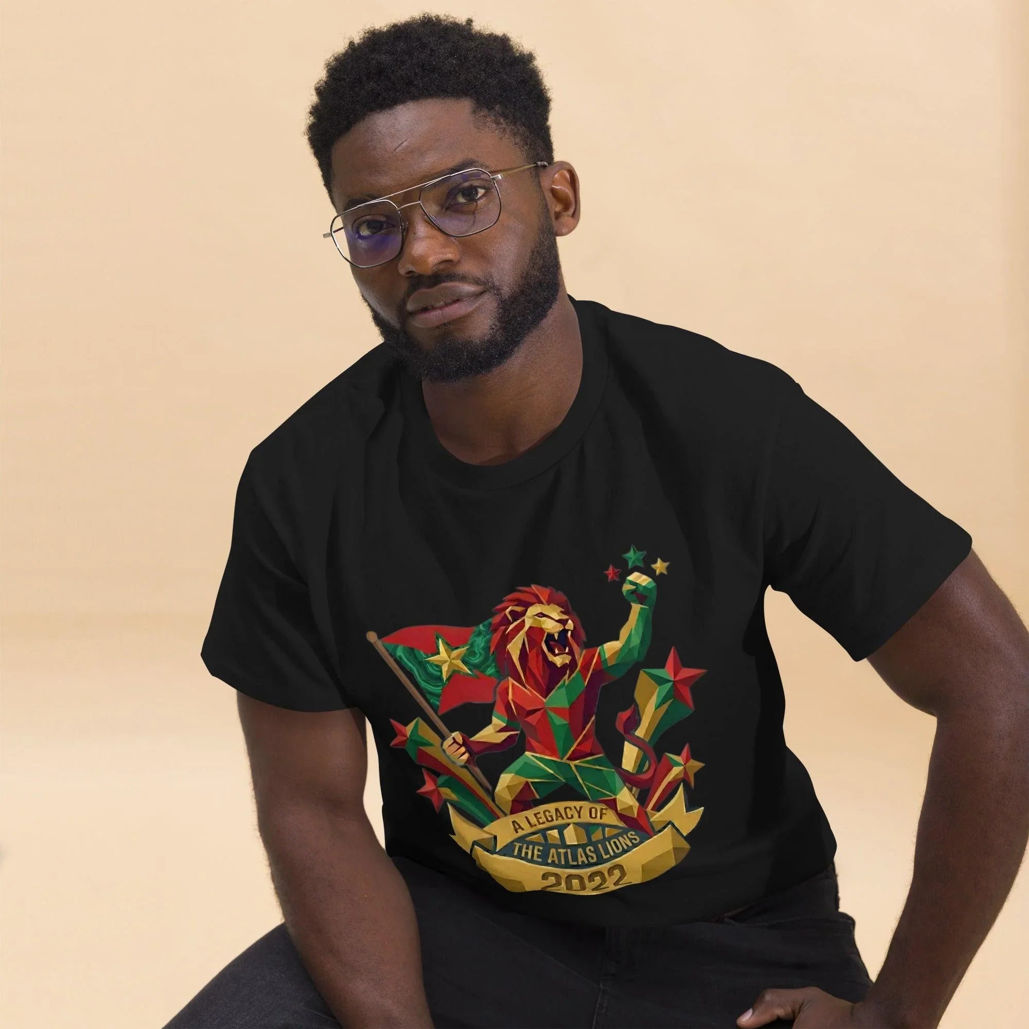 Man wearing black t-shirt with geometric lion design, 'A Legacy of the Atlas Lions 2022', stars and flag, football fan apparel