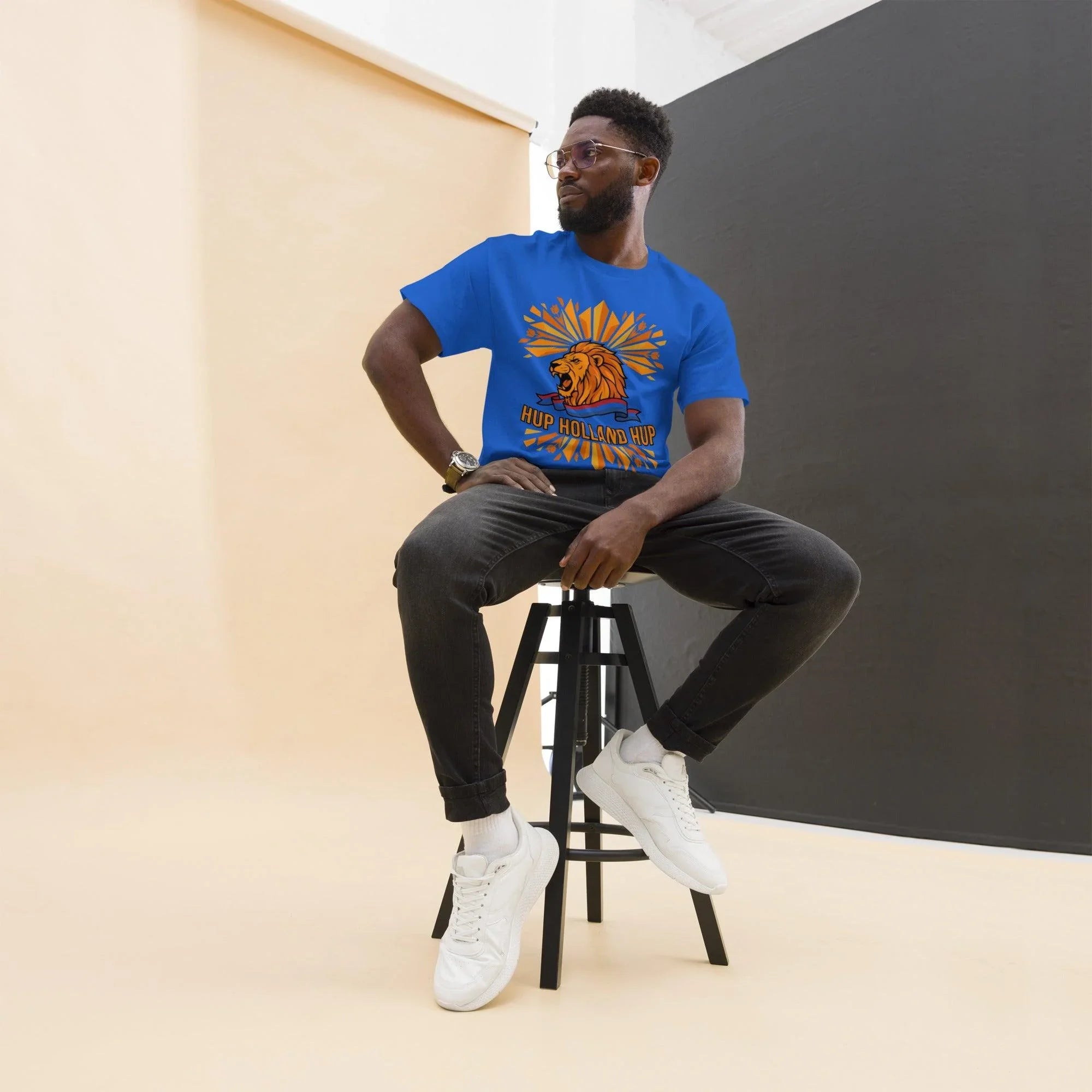 Man wearing blue 'Hup Holland Hup' lion graphic t-shirt, perfect for football fans and sports apparel lovers.